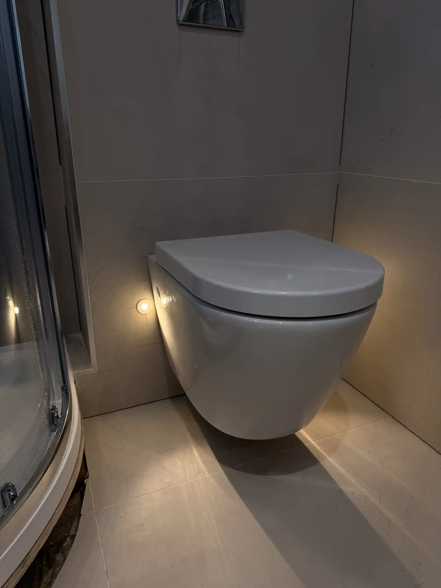 A white toilet sitting in a bathroom next to a shower.