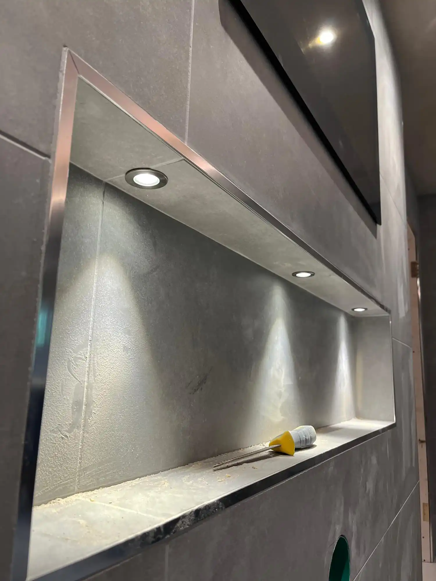 A bathroom with a mirror and lights on the wall.