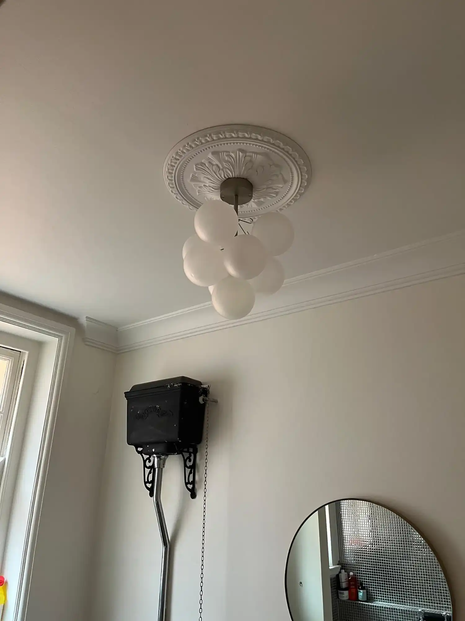 A room with a mirror and a light fixture.