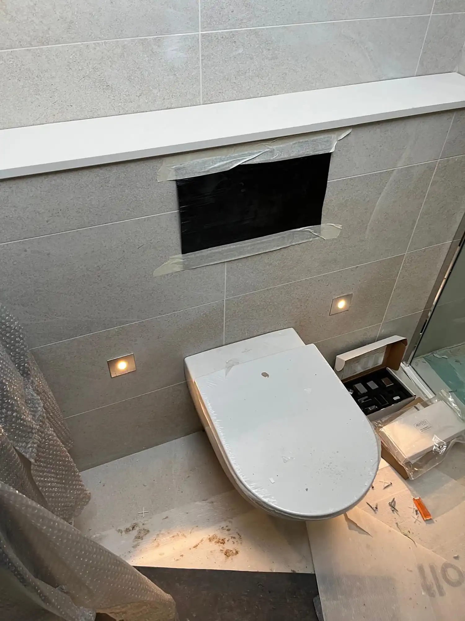 A white toilet sitting in a bathroom next to a window.