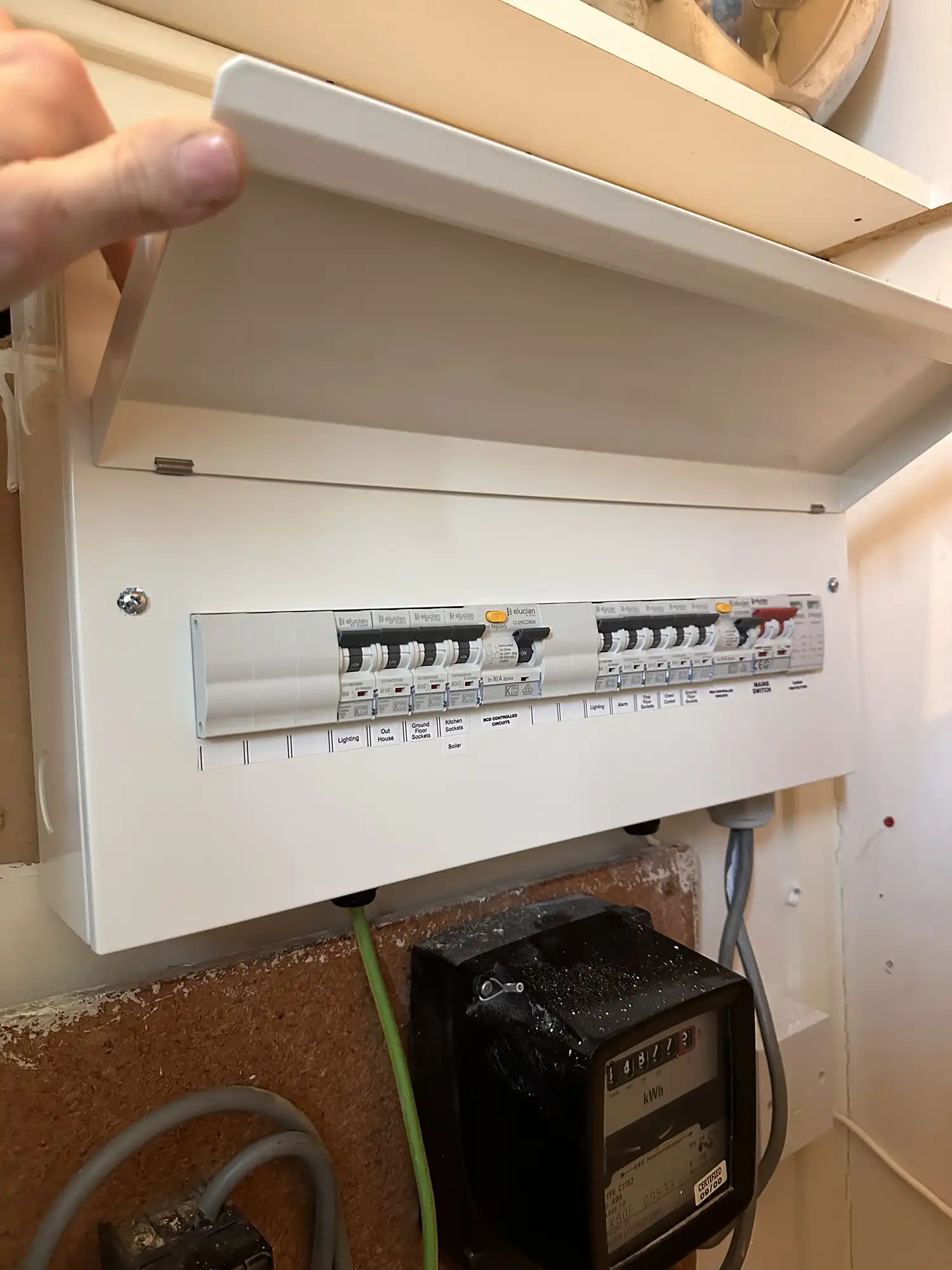 A person opening a consumer unit.